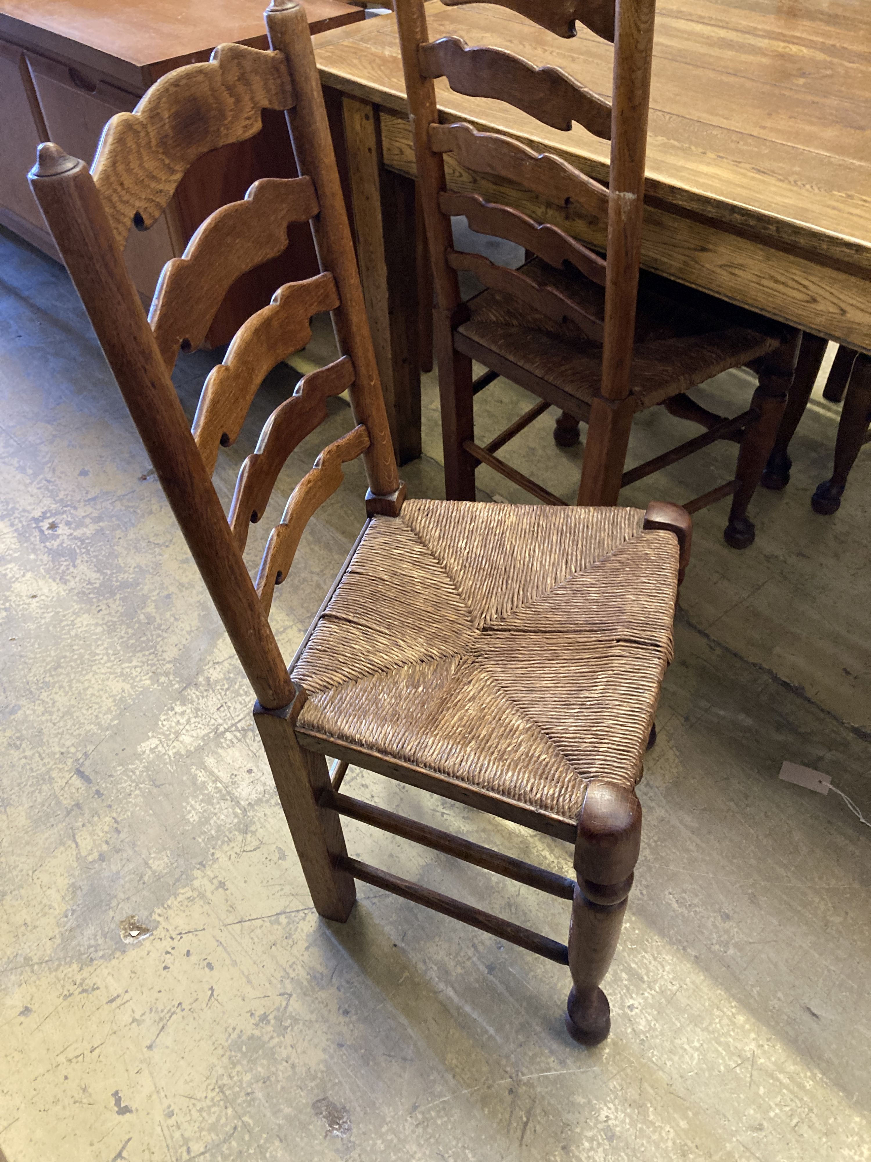 A set of six ladderback dining chairs with rush seats, two having arms